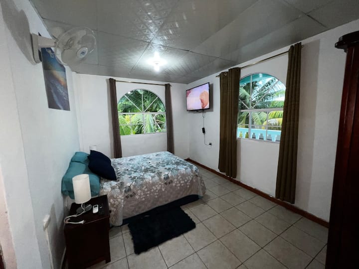 Habitación con 1 cama doble, guardarropa, 1 smart tv, 1 ventilador y aire acondicionado.