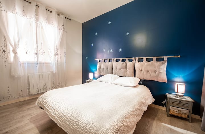 غرفة هادئة بسرير كبير وبياضات ناعمة ومصباح في كل ركن من أركان السرير