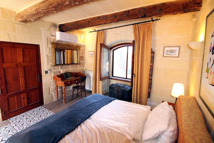 La chambre au premier étage est dans le style architectural maltais. Les lits doubles peuvent être écartés comme dans toutes les chambres et sont alors de 2 lits simples.