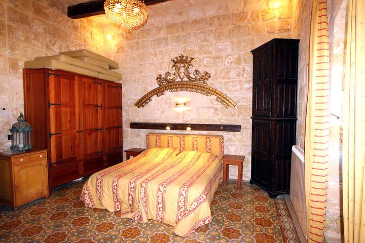 La chambre principale de 4 m de haut d'une superficie de près de 40m2. Comme toutes les chambres (et le salon) climatisés et avec des moustiquaires amovible aux fenêtres.