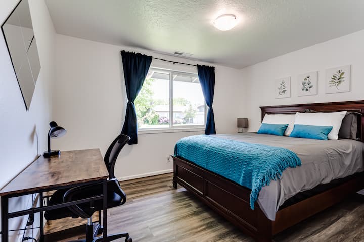 标准双人床、两个床头柜、书桌、椅子和灯具。 