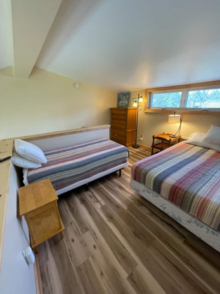 Roshani yenye kitanda cha malkia na kitanda pacha ambacho kinaweza kulala watu 3 kwa starehe.  Inajumuisha bafu kamili kwenye roshani. 