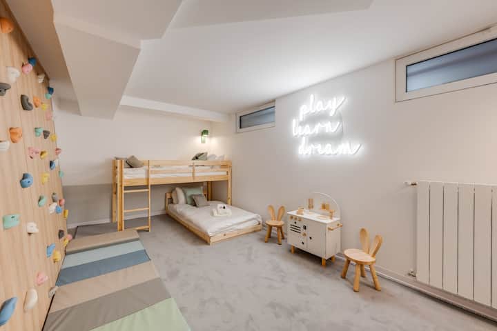 Spavaća soba s krevetima na kat i prostorom za igru za djecu (zid za penjanje i dječja kuhinja)