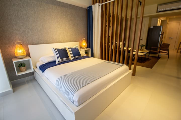 Confortable cama doble con cortinas que separan el dormitorio de la sala de estar. 