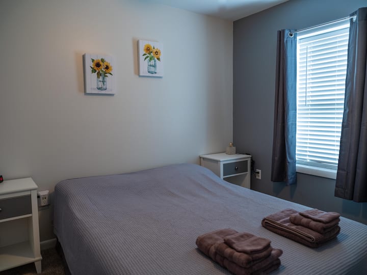 ห้องนอน #1 พร้อมเตียงควีนไซส์โต๊ะหัวเตียงตู้เสื้อผ้าและตู้เสื้อผ้า