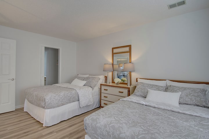 Chumba kikuu cha kulala chenye kabati, bafu, televisheni na mlango wa kujitegemea unaoelekea kwenye roshani.