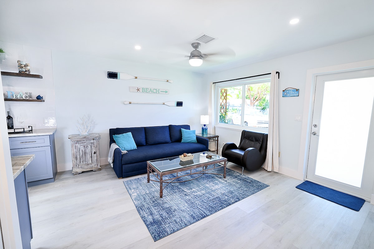 Ingia kwenye nyumba kwenye sebule ya mbele ambayo iko wazi kwa jikoni na sebule ya nyuma. Furahia chumba hiki chenye mwanga na kochi la kustarehesha ambalo hugeuka kuwa kitanda na limepambwa kwa mapambo ya ufukweni.