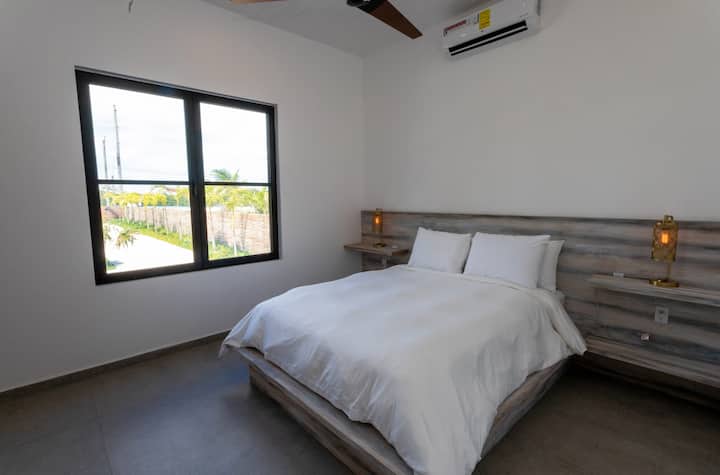 غرفة نوم بمستوى أقل مع سرير بحجم كوين وحمام داخلي