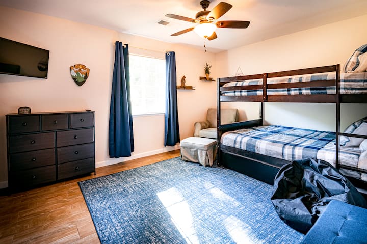 Забавната стая на спрат. Горното легло е двойно легло, главното легло е голямо легло, а стволът е двойно легло. Тази стая се предлага с HD смарттелевизор, затъмняващи щори, кошара за игра и бяла машина за шум. 