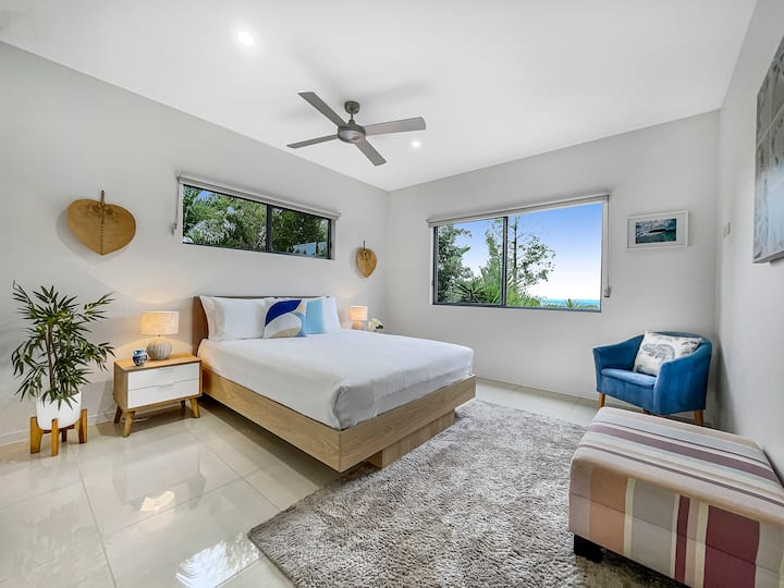 Relax in this bright and airy master bedroom, featuring a comfy queen-sized bed, stylish decor and large windows with gorgeous ocean views. Enjoy the convenience of built-in robes and a private ensuite, making your stay extra comfortable.