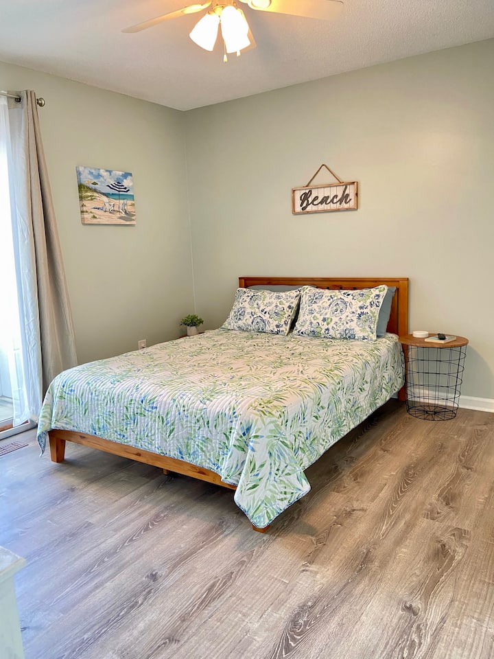 Queen bed with access to second bathroom, 40" Smart TV, and private patio overlooking pool.