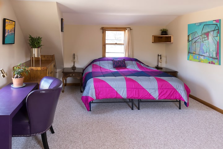 חדר השינה בקומה השנייה מציע מיטת קינג - סייז, שולחן עבודה וארונות מובנים.