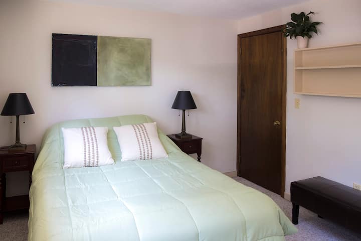 בחדר השינה בקומה הראשונה יש מיטת קווין סייז עם שולחן קטן, שידת מגירות וארון.