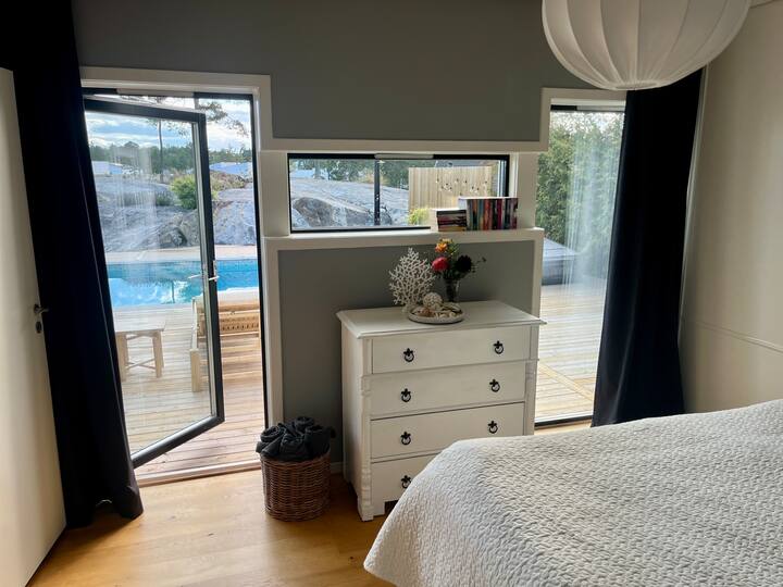 Dormitorio 1 con conexión directa a la piscina y al patio, baño privado.