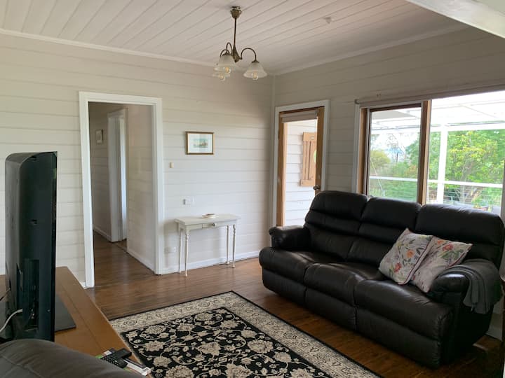 Ukumbi wa televisheni ulio na mlango unaoelekea kwenye vyumba vya kulala. 