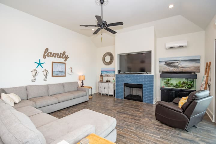 Голема семејна соба со рамен екран, камин и резервоар за риба.  Каучот има брачен кревет.