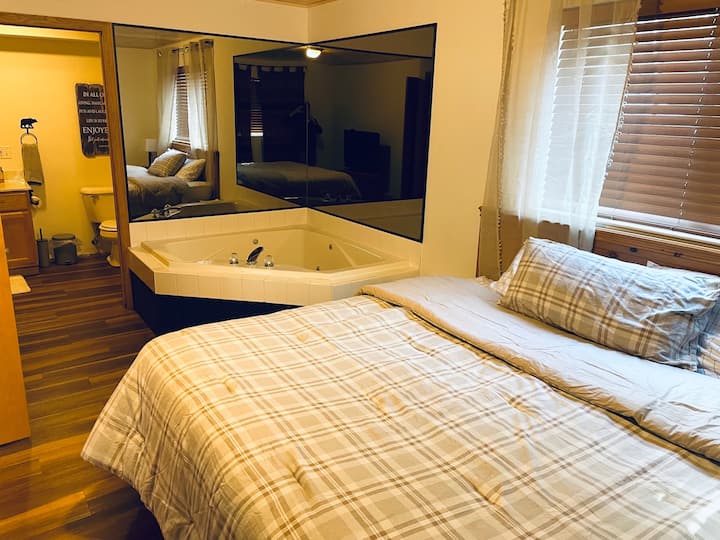 Master slaapkamer met bubbelbad en complete badkamer.