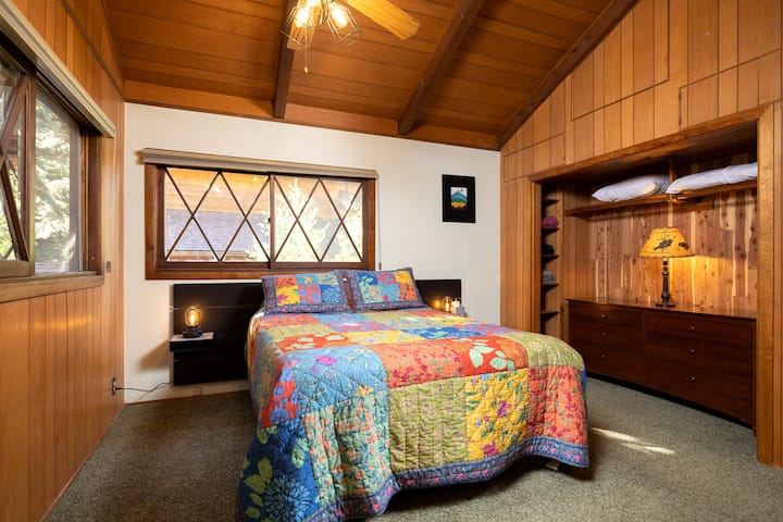 Third floor primary bedroom—we’ve named Camelot Quarters—features a queen bed with memory foam, wonderful woodland views, a private, en suite bath, closet with large dresser, clothes hangers, luggage racks 
