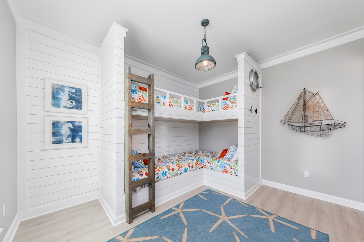 A kid’s dream comes true in this ocean themed bunk room with nautical lighting, porthole & ocean themed bedding! The room has 4 twin beds, storage console, 50” Smart TV & DVD player. Kids will “seas the moment” on their vacation with “Shipwrecked”! 