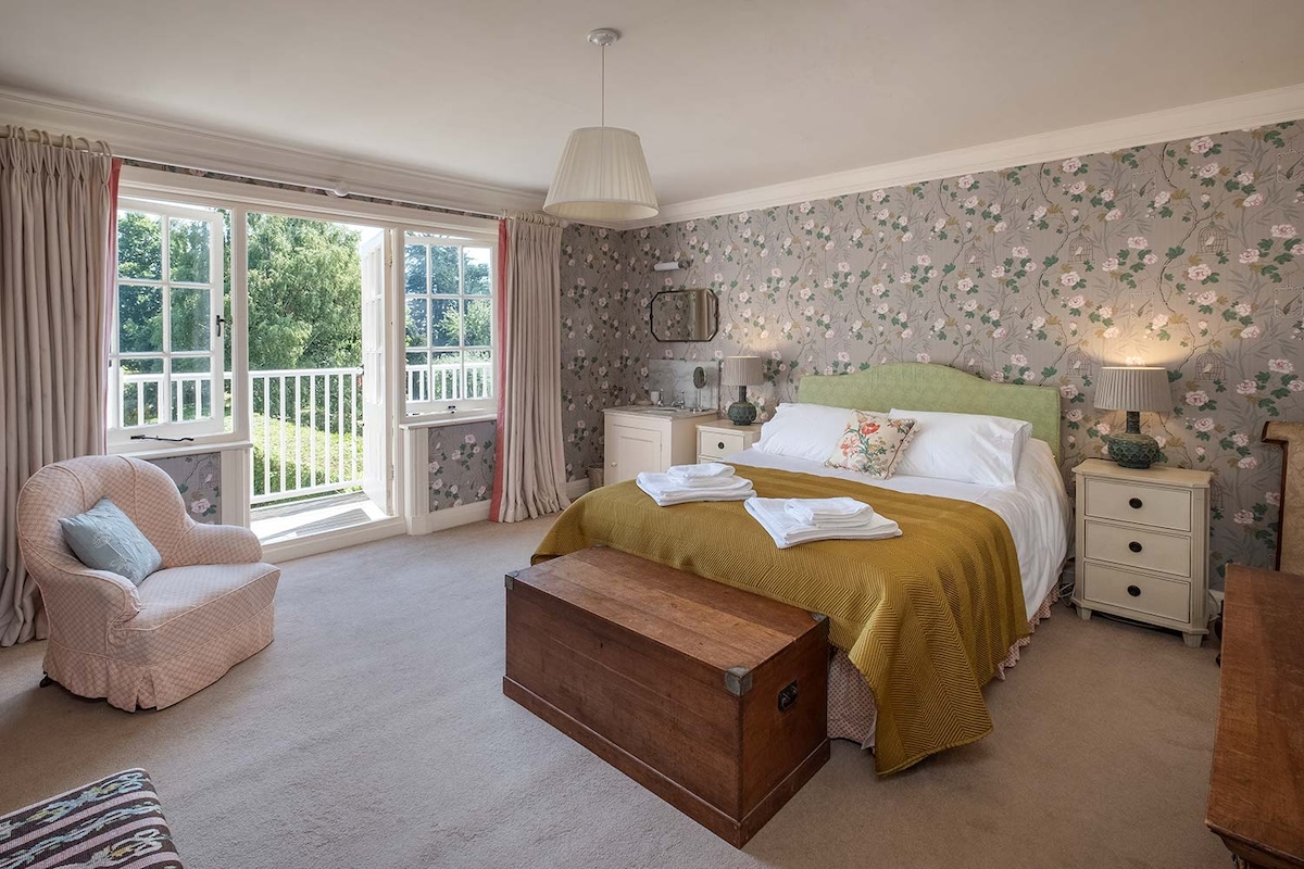 Ce lit king size donne sur le jardin et dispose d'un balcon, d'un évier dans la chambre également.