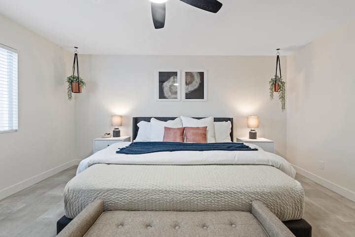 חדר שינה ראשי מרווח עם מיטת קינג סייז וטלוויזיה 55אינץ '