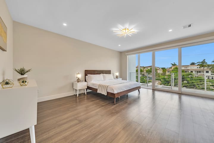 غرفة نوم رئيسية كبيرة وسرير بحجم كبير مع شرفة. 