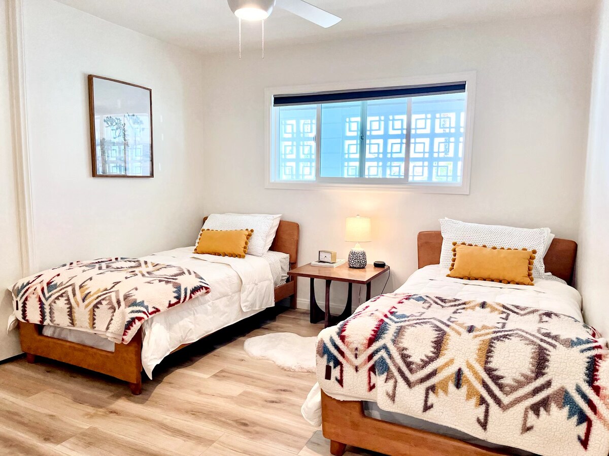 第三间卧室（「儿童房」）有两张单人床、一个衣柜和边桌。 这个房间的窗帘是遮光帘，吊扇有助于保持房间的通风。