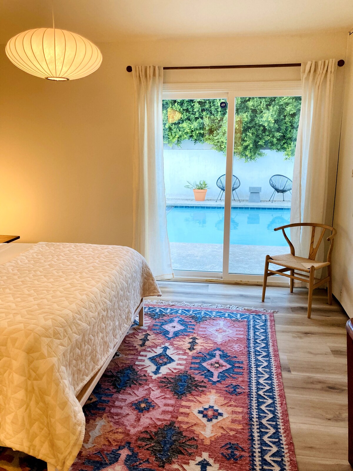 第二间卧室，通往泳池的门。这个房间里有一张书桌（在右侧的照片中被切断） ，因此这里是躲避并跳上Zoom通话或工作的好地方。