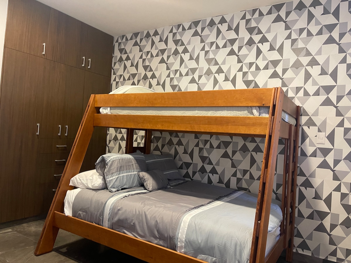 Recámara secundaria con cama matrimonial abajo y cama individual arriba y en la parte de abajo de la matrimonial hay una cama individual 