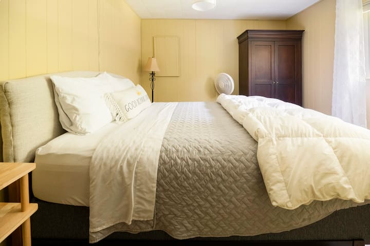 ห้องนอนใหญ่พร้อมเตียงควีนไซส์และห้องน้ำครึ่งห้อง