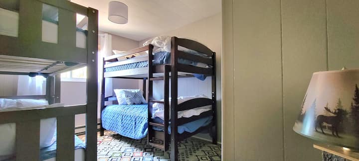 ห้องนอนพร้อมเตียงแฝด 4 เตียงและสมาร์ททีวี