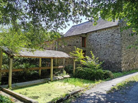 Breton stone cottage with a garden near the river