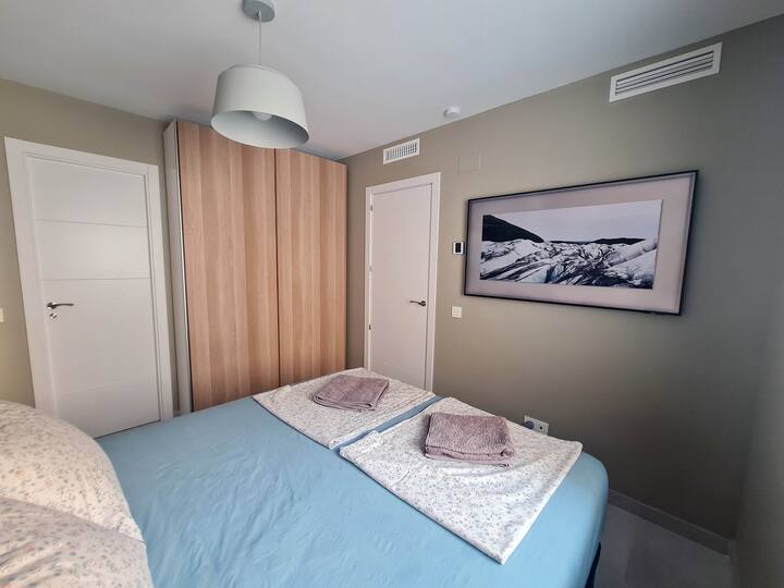 Master bedroom with bathroom and tv.