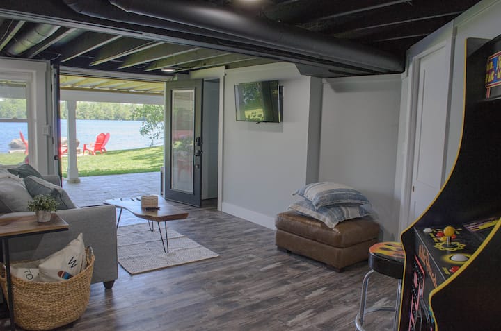 finished lower level with patio doors open to patio and backyard, with pull out queen sofa, arcade game, dart board, smart TV, 1 bedroom and full bath