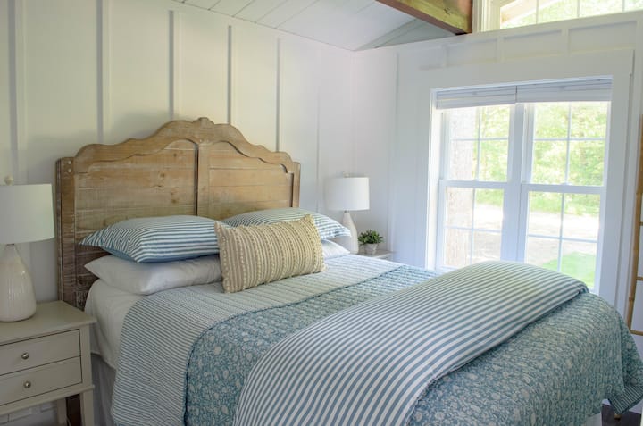 Modern coastal queen bedroom with farmhouse elements including vaulted ceiling and closet with luggage racks