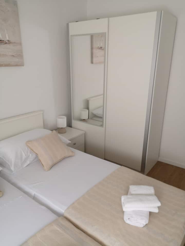 Bed room with two single beds, and closet.