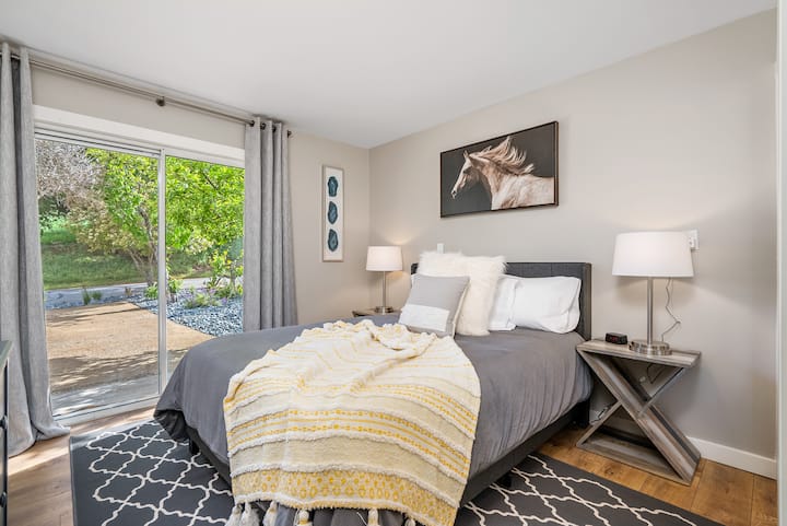 2nd bedroom, lower level guest bedroom with Queen size bed, en-suite bathroom, closet, smart TV and sliding door. 