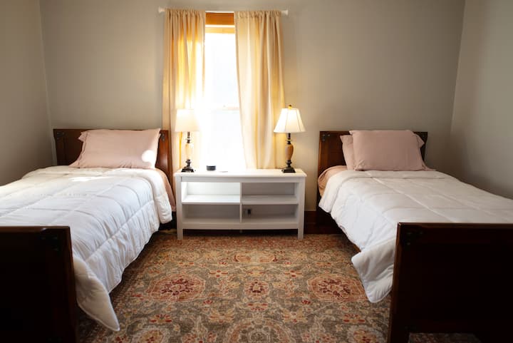 غرفة نوم تضم سريرين صغيرين