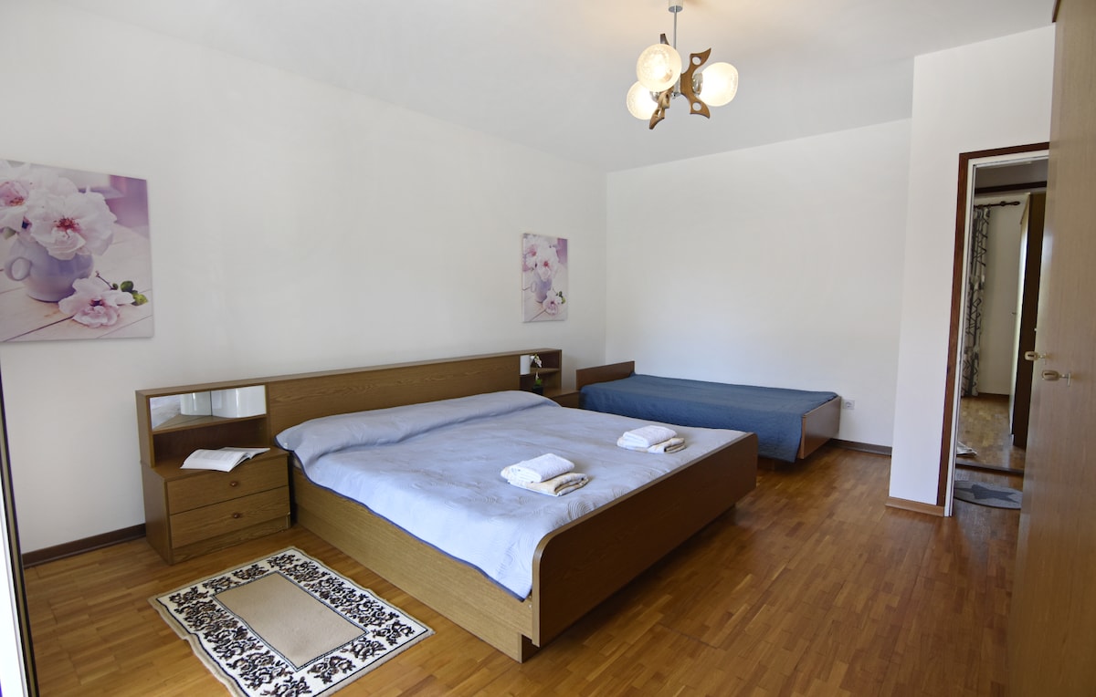 ห้องนอน 3 พร้อมเตียงคู่และเตียงเดี่ยวโต๊ะข้างเตียง 2 ตัวพร้อมโคมไฟกลางคืน