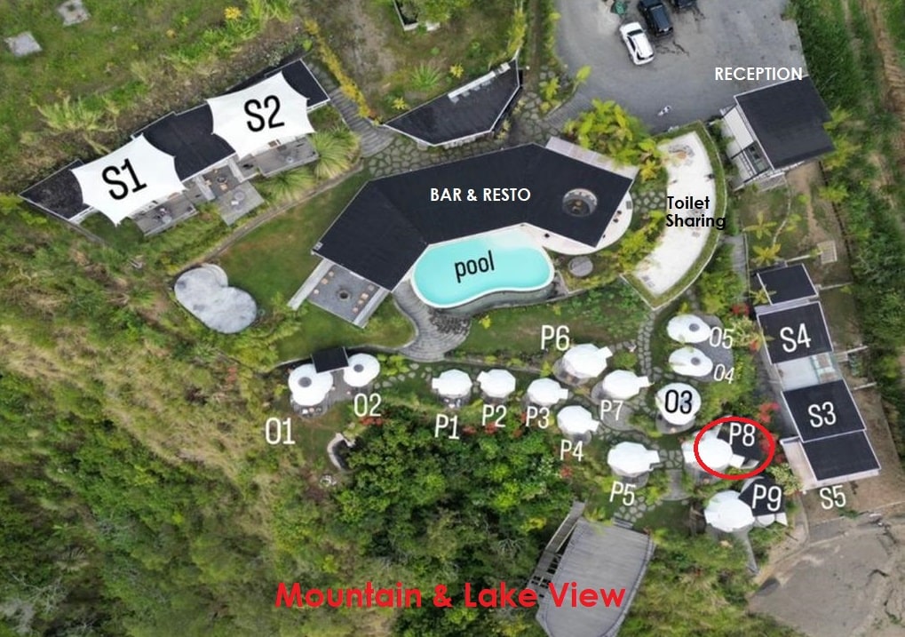 An aerial view showcases the layout of the accommodation, including a central swimming pool, bar, and restaurant. Different room types are visible, as well as designated areas for outdoor seating, all set against a backdrop of mountains and lake views.