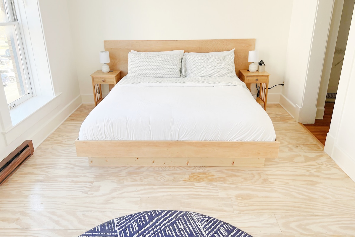 Our huge bedroom has a king-sized bed and seven-foot windows with blackout blinds. There's a white noise machine and a ceiling fan to help you sleep like a baby.