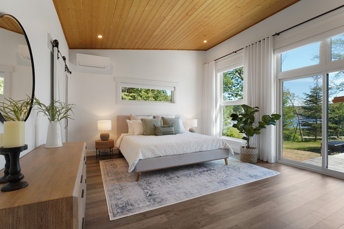 Primary bedroom with king bed, smart TV, desk, exercise bike, and patio access.