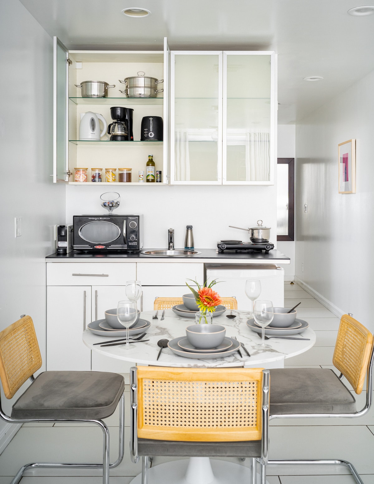 Dining area and equipped compact kitchenette with open cabinets