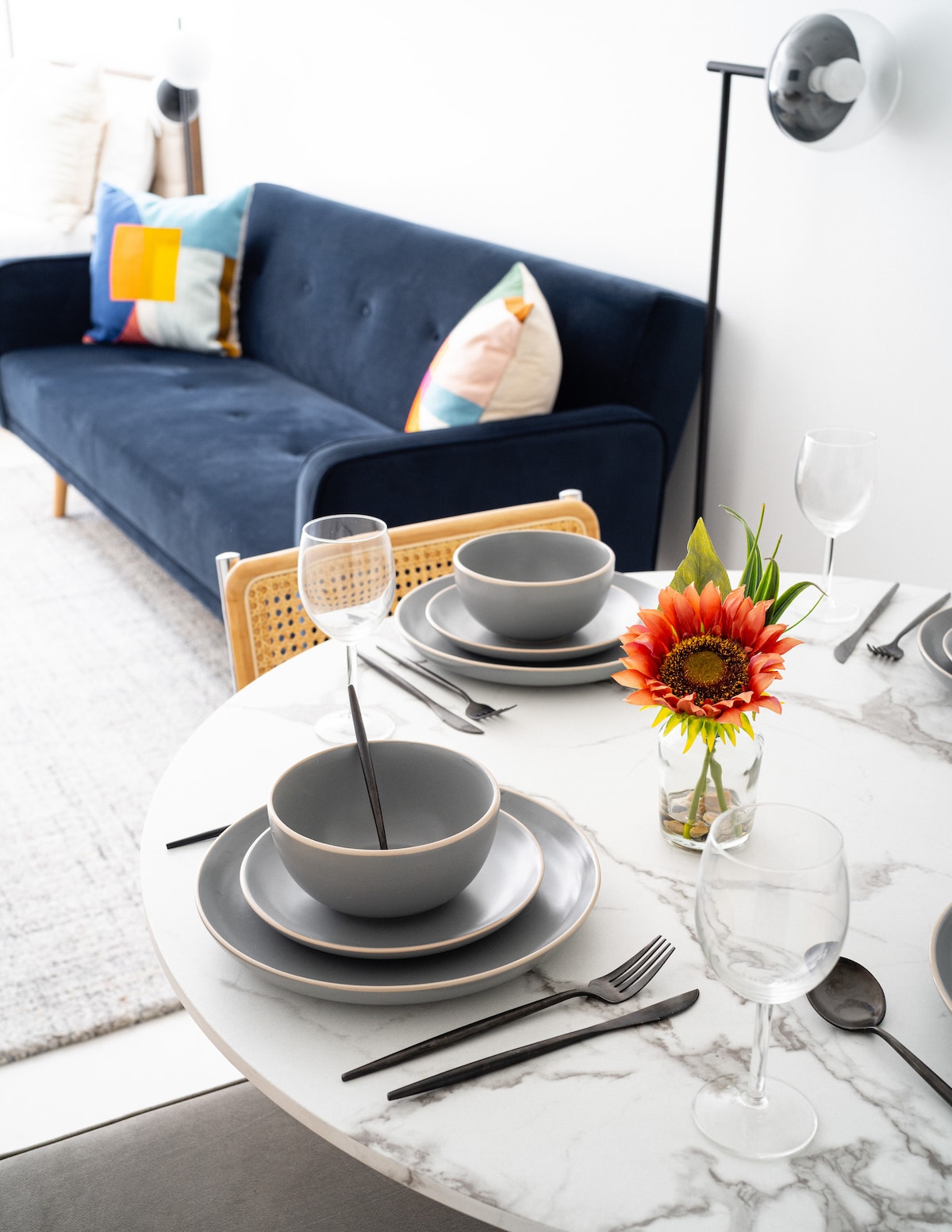 Detail of the set dining table beside the blue sofa