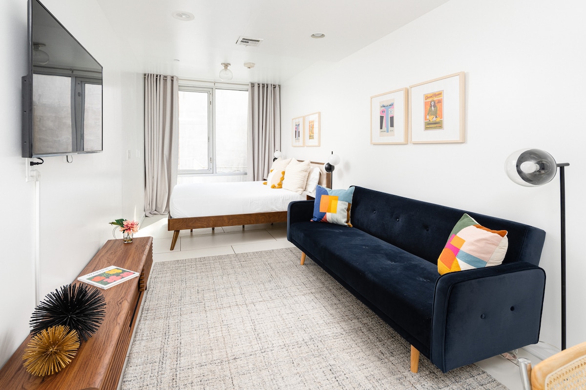 Bright living area with sofa bed, television, and large window