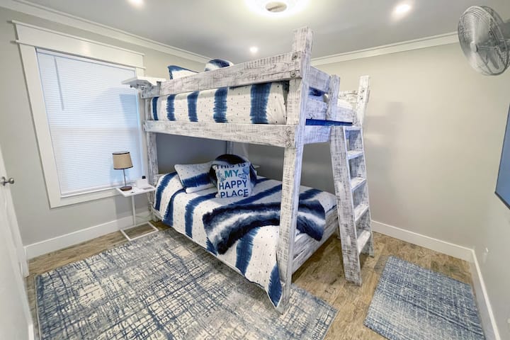 Dormitorio2 -literas tamaño queen - Depósito pesado hecho a medida para adultos y niños.  Mesas de noche junto a la cama con enchufes USB/enchufes, literas superiores con bandejas laterales para almacenar (botella de agua y teléfono), ventilador de pared oscilante y un televisor inteligente Roku de 55pulgadas.