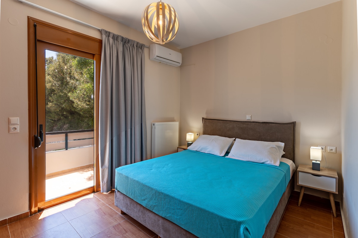 Spálňa s manželskou posteľou a jasne modrou posteľnou bielizňou.