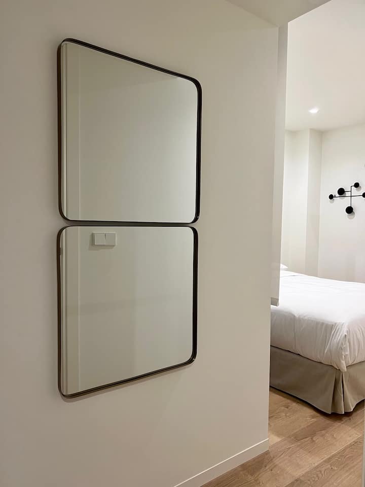 غرفة نوم أنيقة بسرير مزدوج وخزانة مع شماعات وتلفزيون