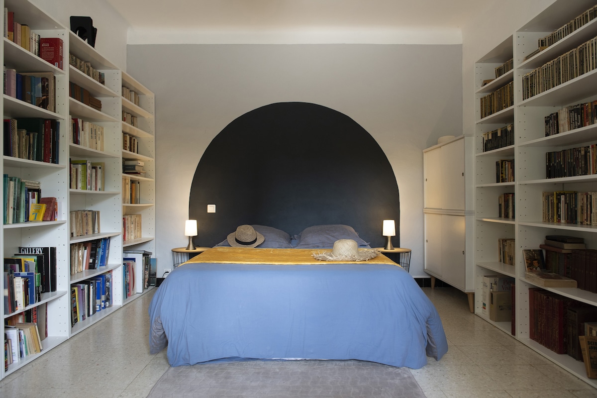 It's called the bedroom in the arch. It is on the ground floor of the house and in a row with another bedroom . The ubiquitous reading in the house comes out here with these libraries. It is also equipped with a TV. Views of the garden