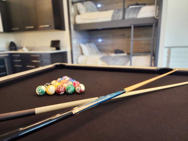 Pool table with beverage center and bunks in same room.